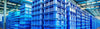 Row of blue plastic crates stacked in a warehouse.