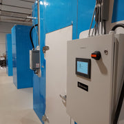 Control panel with digital display and blue DC units in a room.